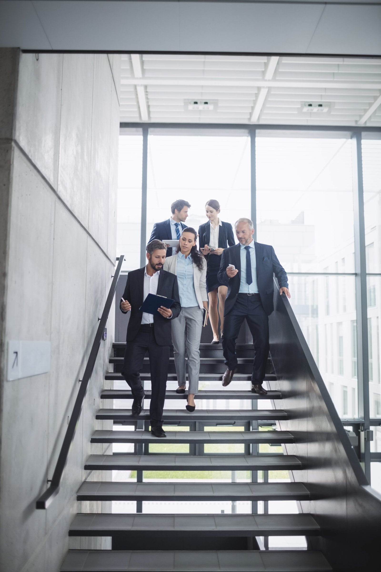 Confident businesspeople standing on staircase in office